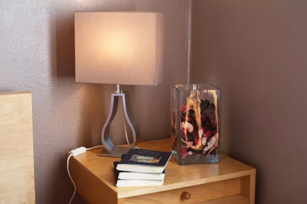 Bedside table with a lamp next to the bed