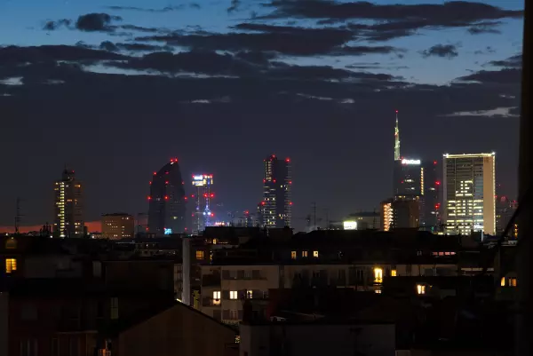 Milan's skyscrapers lit up at night, seen from the terrace