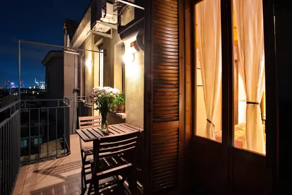 Corner of the terrace with table and flowers, lit at night